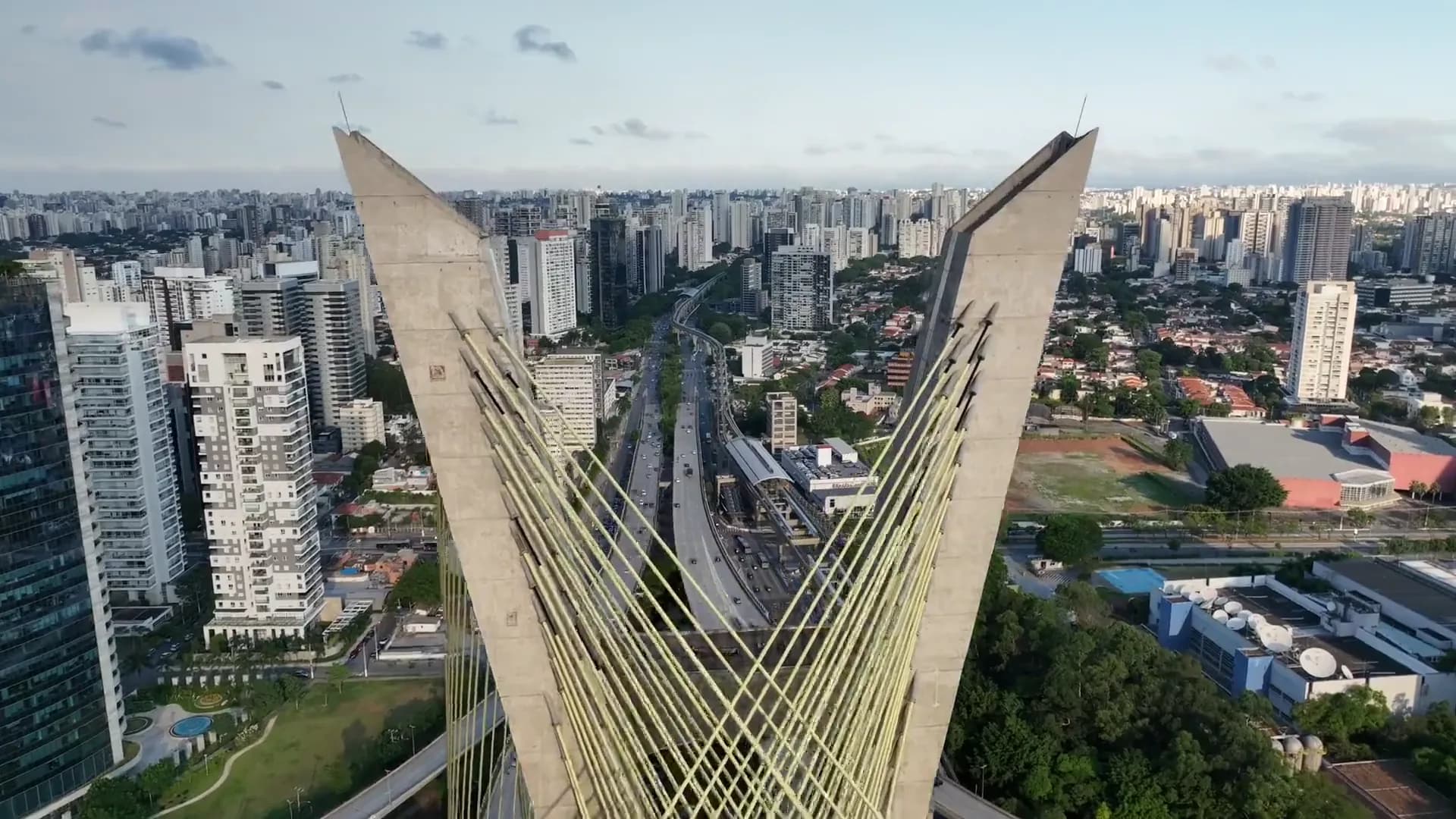 Aerial view of a cable-stayed bridge over a dense city skyline